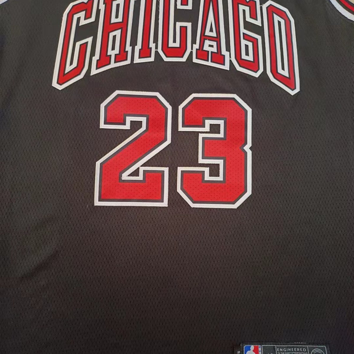 גופיית כדורסל שיקגו בולס מספר 23 שחור | כיתוב CHICAGO אדום (תקריב של הבד וההדפס)