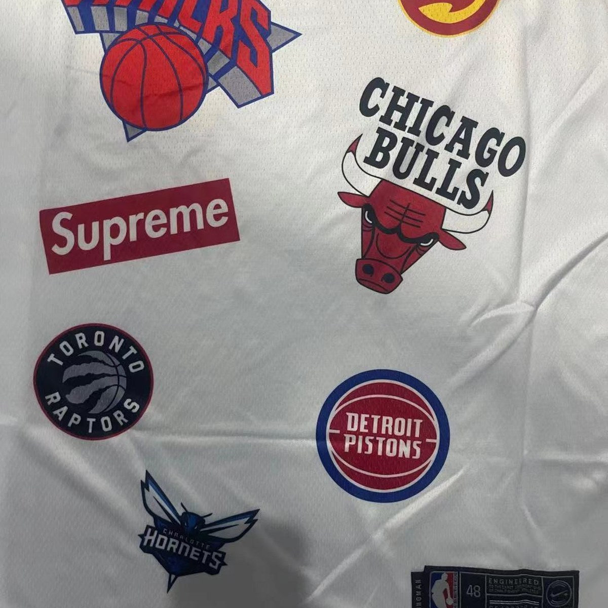גופיית כדורסל בעיצוב NBA ו־Supreme מספר 94 לבן (תקריב של הבד וההדפס)