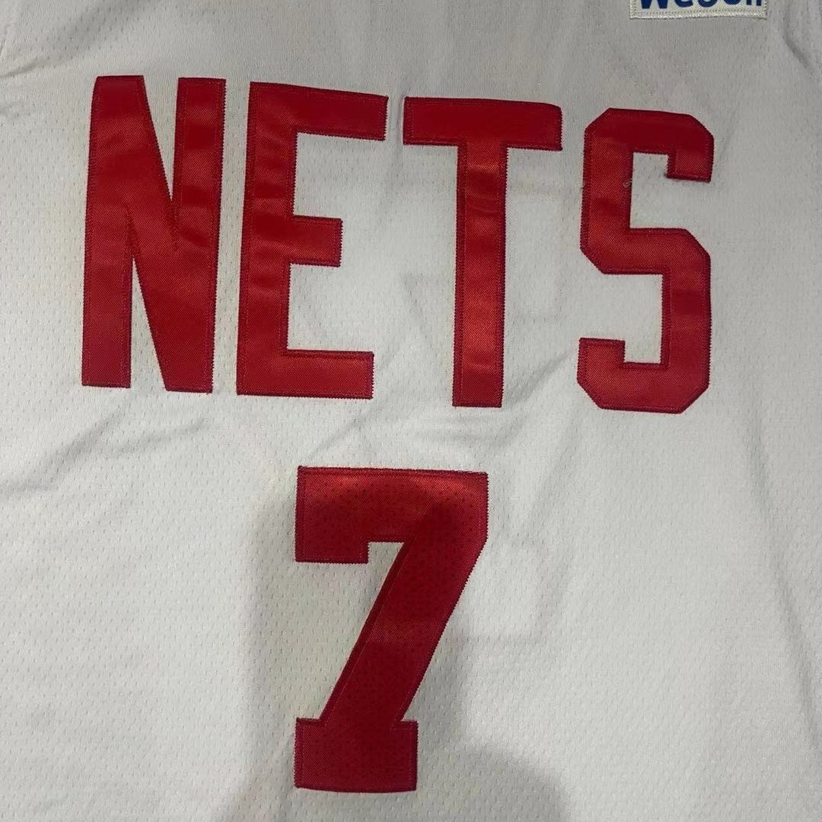 גופיית כדורסל ברוקלין נטס מספר 7 לבן | כיתוב NETS אדום וכוכבים בצד (תקריב של הבד וההדפס)