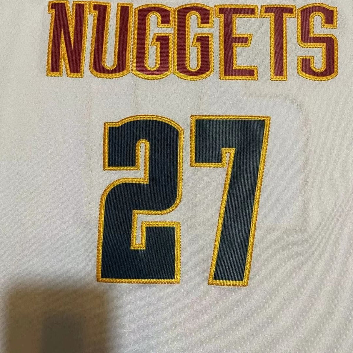 גופיית כדורסל דנבר נאגטס מספר 27 לבן | כיתוב NUGGETS ועיטור צהוב (תקריב של הבד וההדפס)