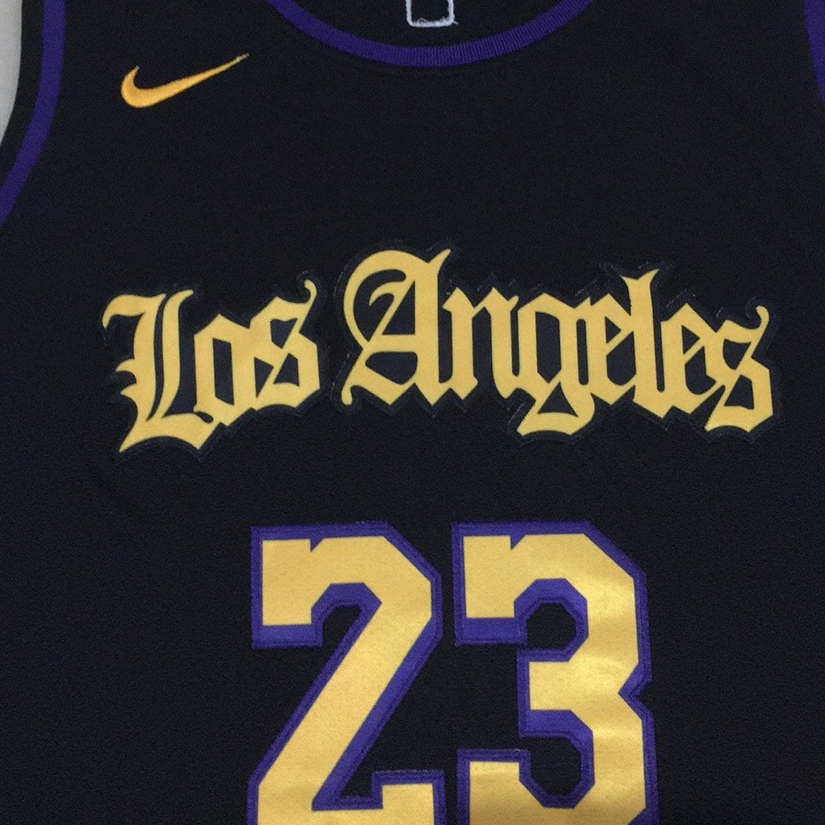 גופיית כדורסל לוס אנג׳לס לייקרס מספר 23 שחור | כיתוב Los Angeles מסולסל (תקריב של הבד וההדפס)