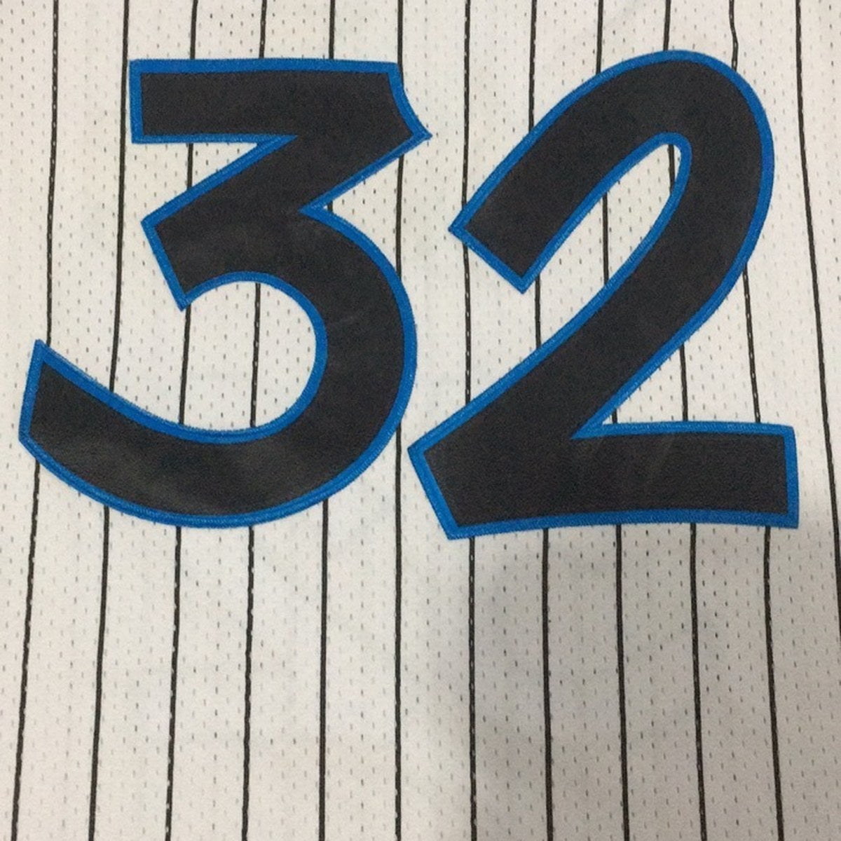 גופיית כדורסל אורלנדו מג׳יק מספר 32 לבן רטרו פסים (תקריב של הבד וההדפס)