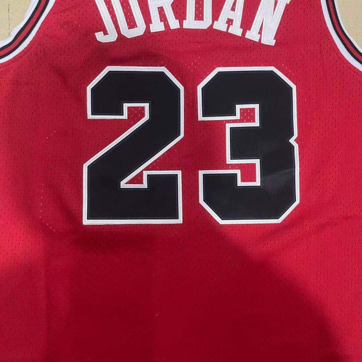 Chicago Bulls #23 Basketball Jersey – Red, Retro, Chicago Lettering and Black Jock Tag (close-up of the fabric and print)